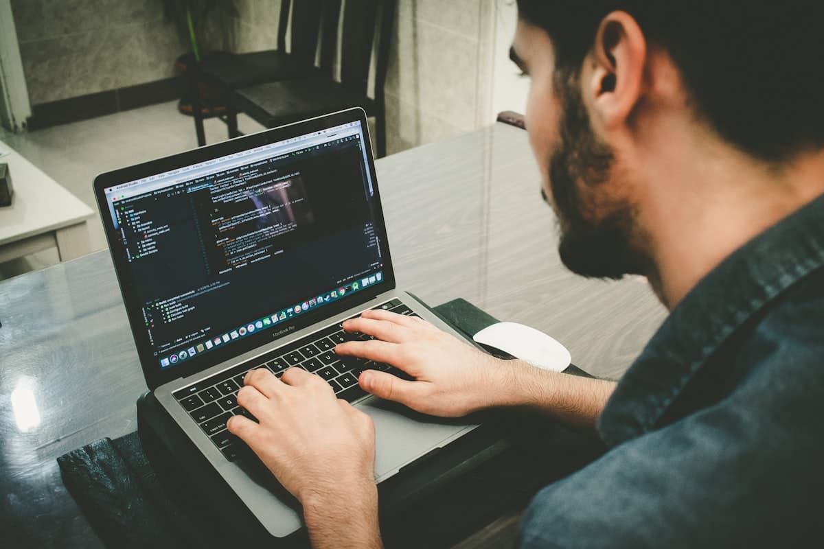 Desenvolvedor analisando código em laptop — revisão de software