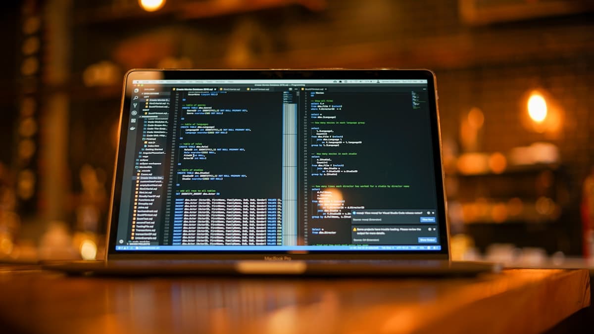 Monitor exibindo código de software em ambiente de desenvolvimento profissional